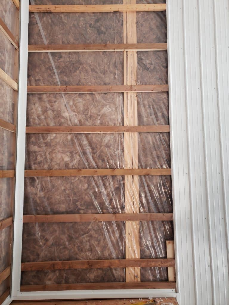 Insulated walls of a post-frame building